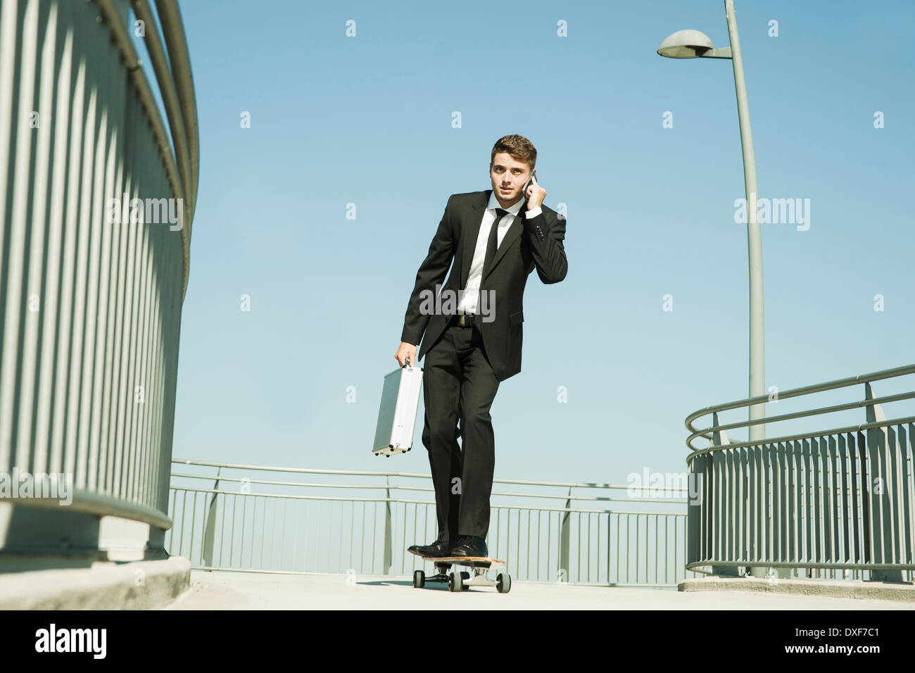 Businessman using Cell Phone while Skateboarding, Mannheim, Baden-Wurttemberg, Germany Banque D'Images