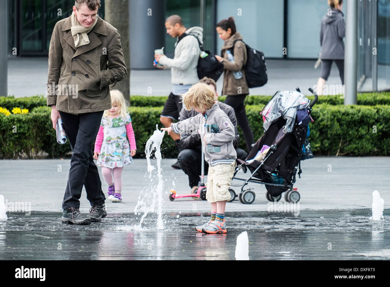 Un jeune garçon joue avec les fontaines sur la rive sud de Londres Banque D'Images