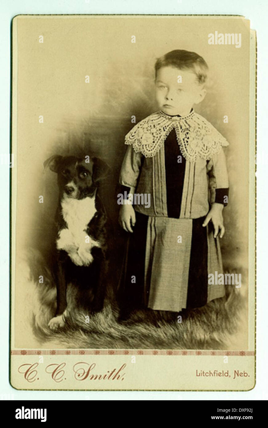 Enfant avec col en dentelle, posés avec chien Banque D'Images