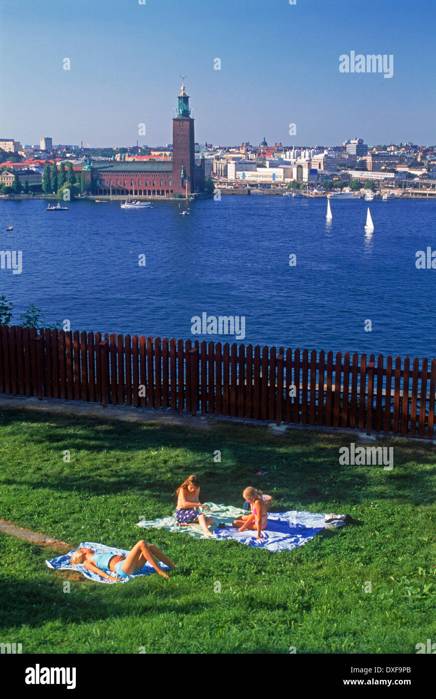 Pique-niques d'été, les bains de soleil et la voile à Stockholm avec l'ensemble de l'hôtel de ville des eaux Riddarfjarden Banque D'Images