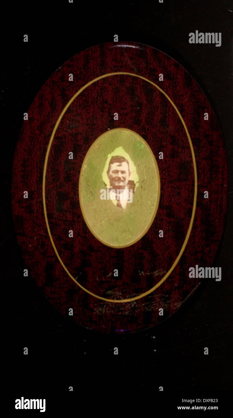 Cette photographie vintage représente un homme avec une moustache, portant une cravate, du début du XXe siècle. La photographie reflète la mode et le comportement de la période, mettant en valeur le style masculin au début des années 1900 Banque D'Images