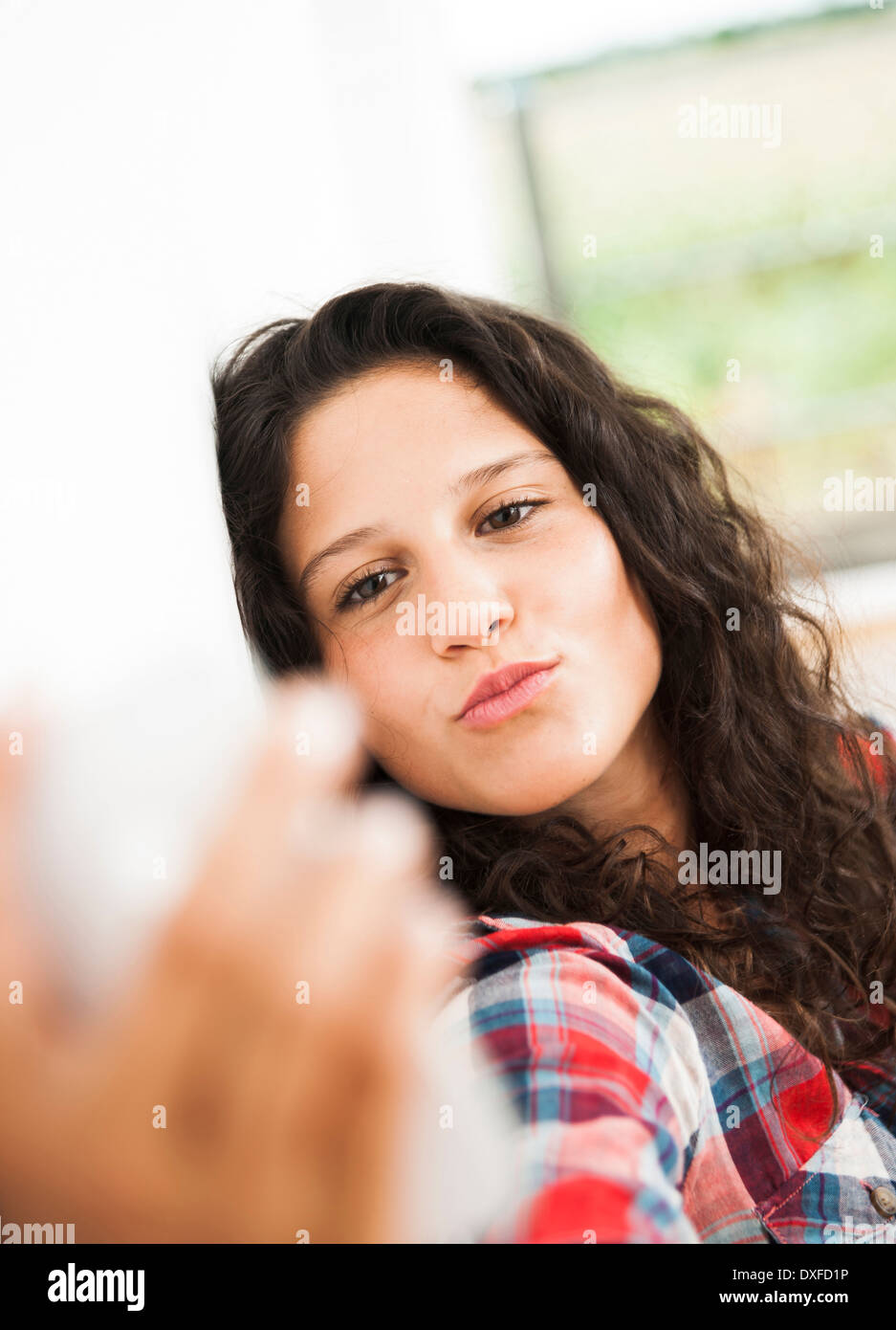Teenage girl posing et en tenant avec selfies smart phone, Allemagne Banque D'Images
