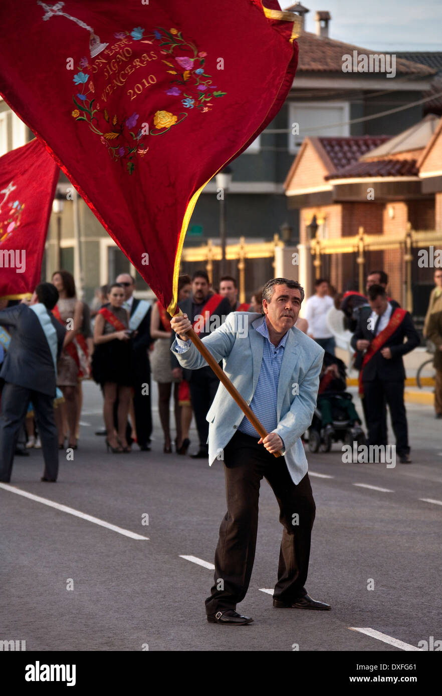 Homme de la région de brandir le drapeau à la Fiesta de la Santisima Cruz - Costa del Sol Espagne Région de spouthern Banque D'Images
