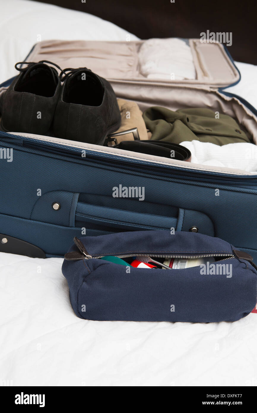 Men's Toiletry Bag de voyage à côté de paniers-valise sur le lit, USA Banque D'Images