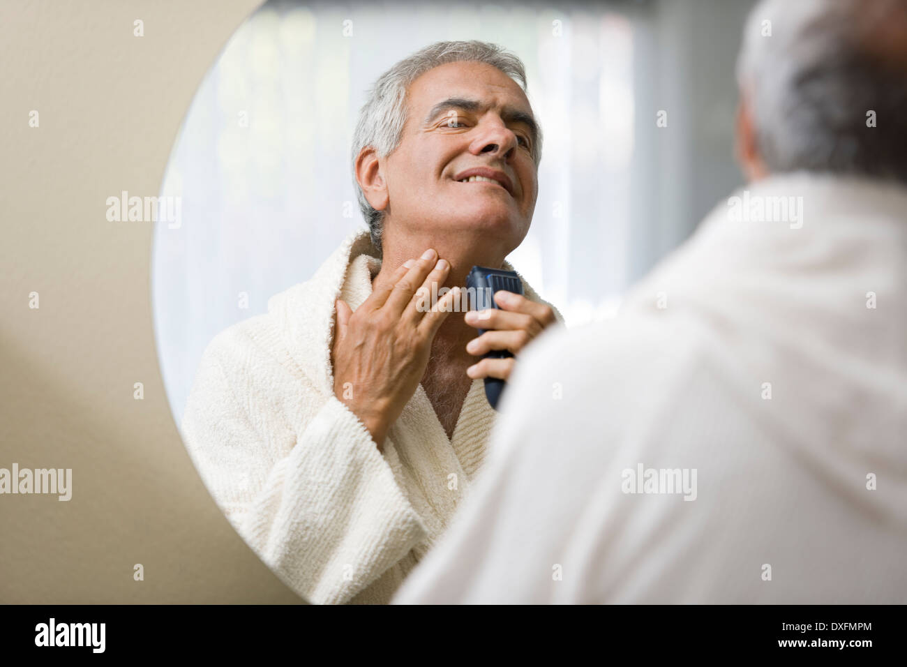 Homme mature en miroir de rasage Banque D'Images