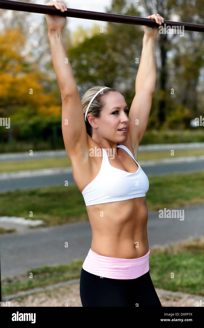 Close Up Portrait of View of a fit Woman Performing Tirer vers le haut l'exercice à l'extérieur dans un parc Banque D'Images