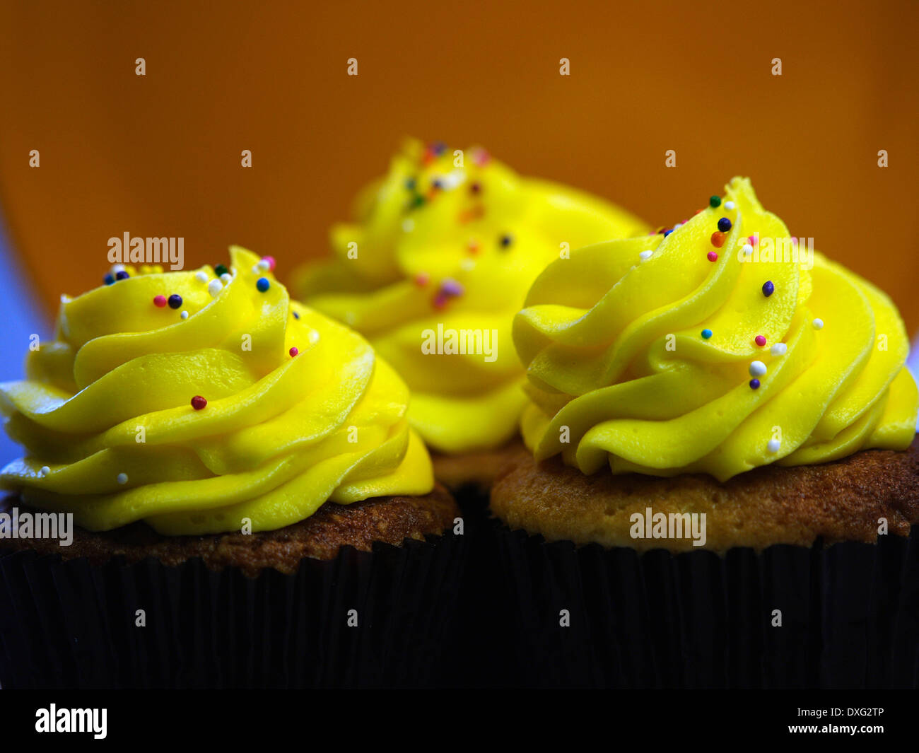 Trio de Cupcakes glacé jaune dans une rangée Banque D'Images