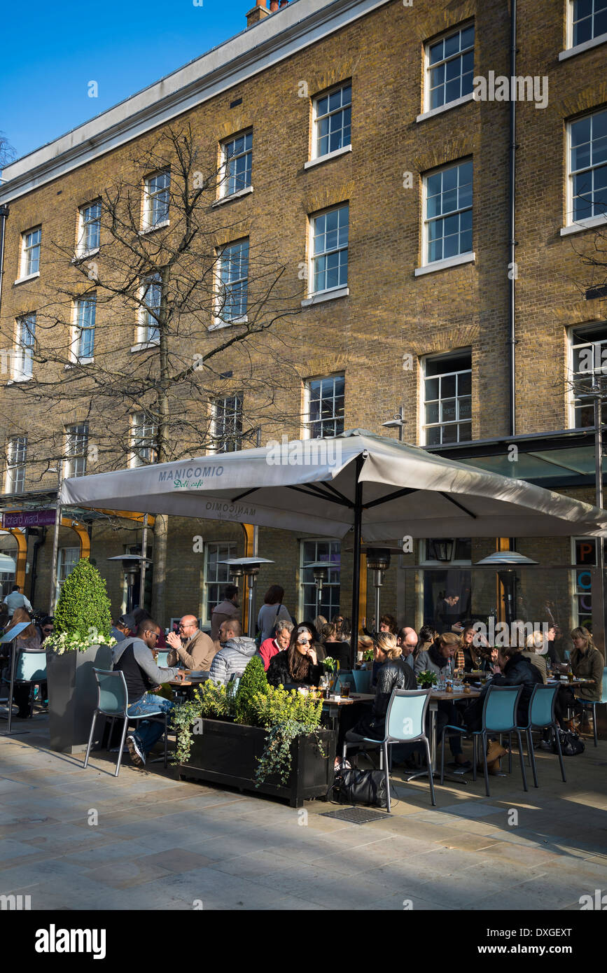 Des gens assis sur la terrasse de Manicomio restaurant et café, Duke of York Square, King's Road, Chelsea, London, UK Banque D'Images