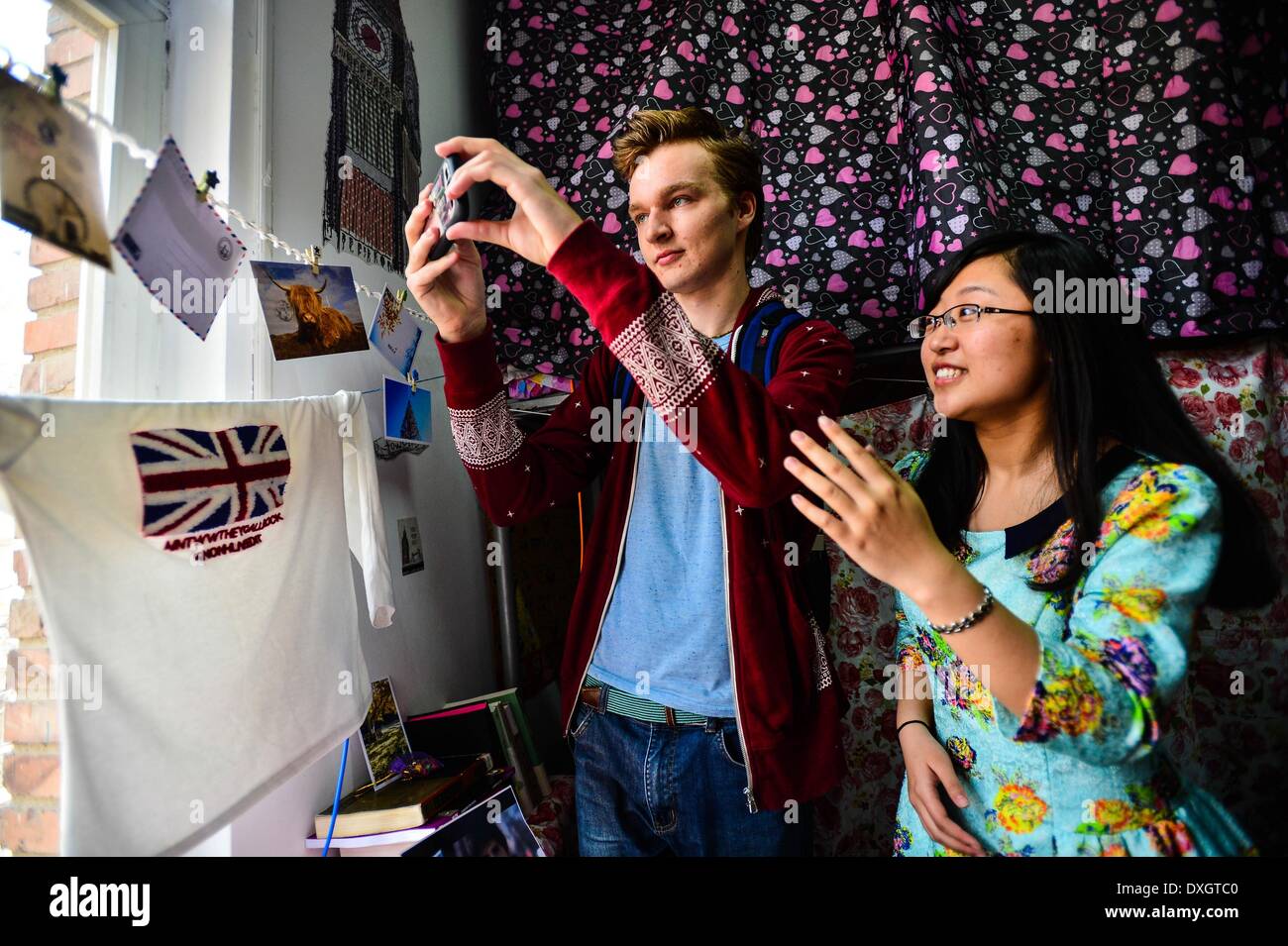 Tianjin, Chine. Mar 26, 2014. Le concepteur (R) présente les détails de décoration à un juge à la Grande-Bretagne un thème-dortoir à l'université Nankai, à Tianjin, Chine du nord, le 26 mars 2014. L'ordre de la langue et de la culture chinoises de l'université Nankai a lancé un concours de design de style dortoir parmi les étudiants récemment. Les élèves utilisent les articles à la main pour décorer leur dortoir avec un thème particulier montrant la culture de différents pays et régions. © Vous Sixing/Xinhua/Alamy Live News Banque D'Images