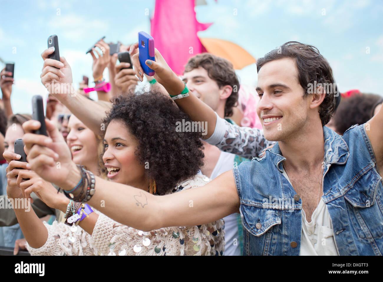 Téléphones portables avec appareil photo avec des fans cheering at music festival Banque D'Images