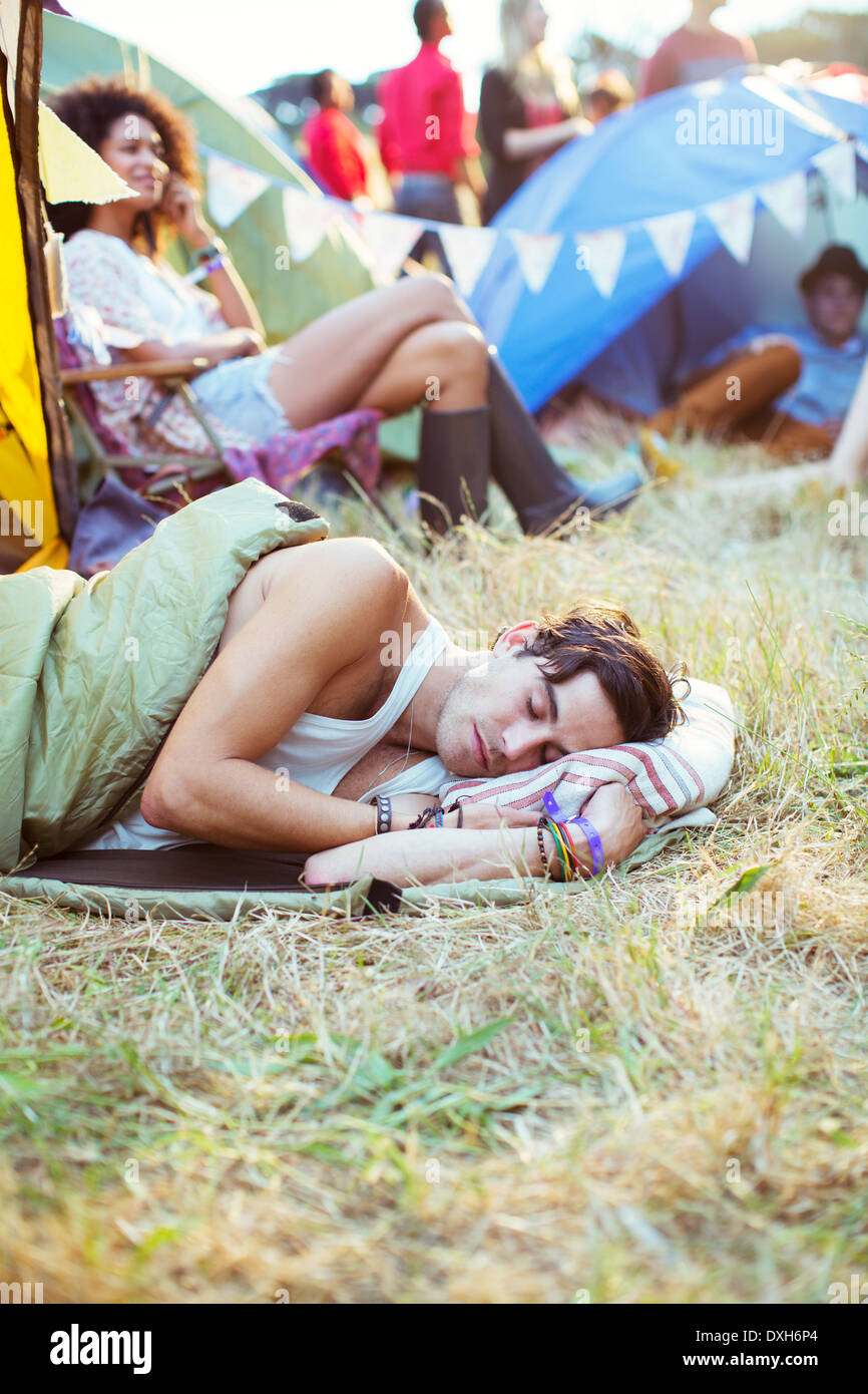 L'homme en sac de couchage tentes dormir dehors au festival de musique Banque D'Images