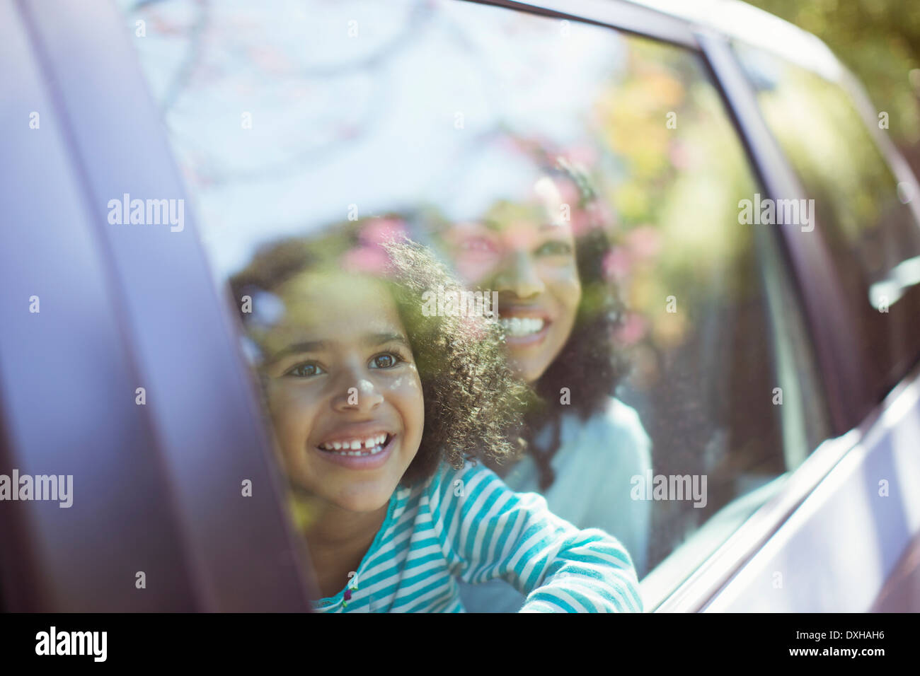 Happy mother and daughter looking out car window Banque D'Images