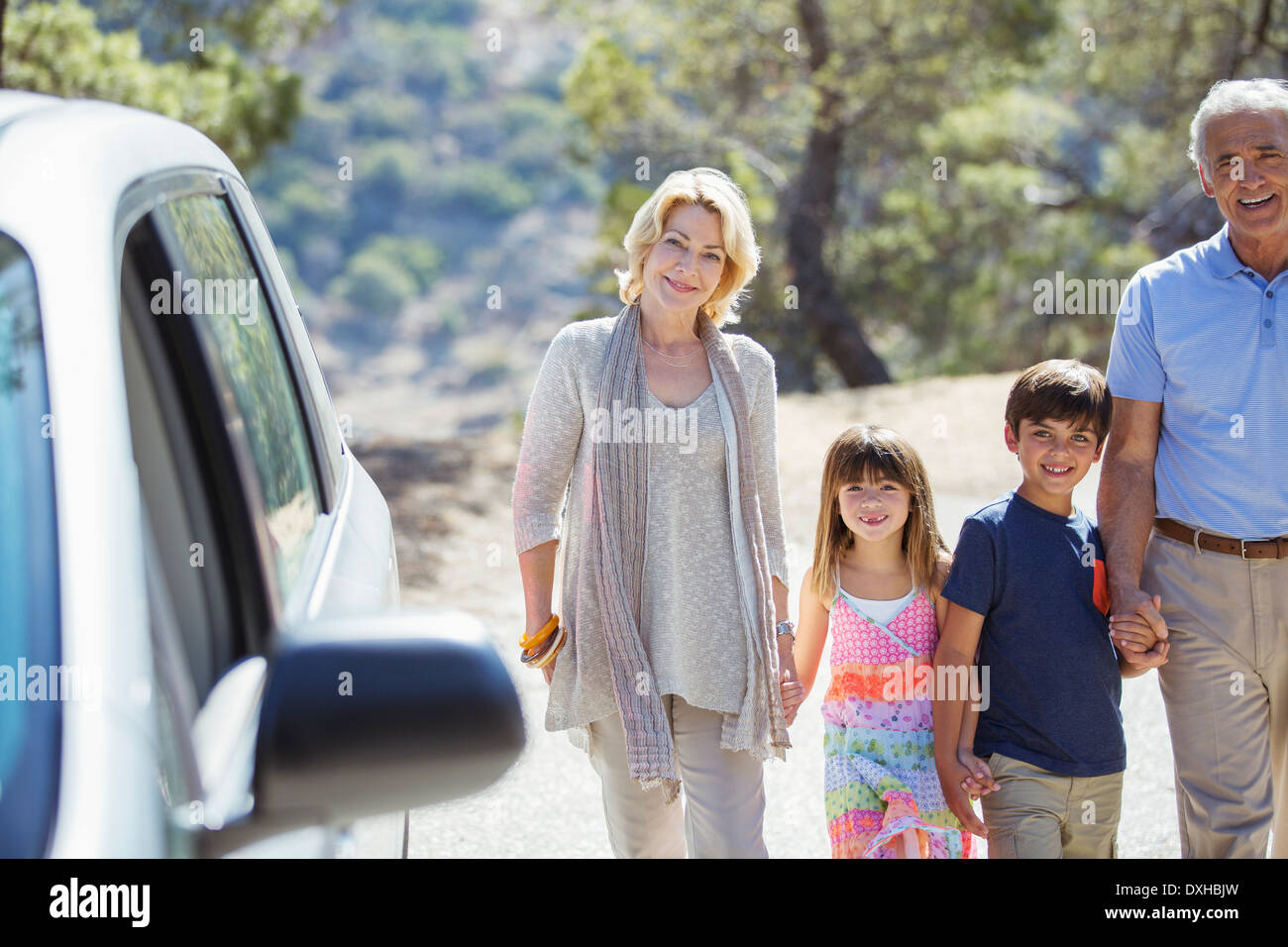 Les grands-parents et petits-enfants se tenant la main à l'extérieur de voiture Banque D'Images