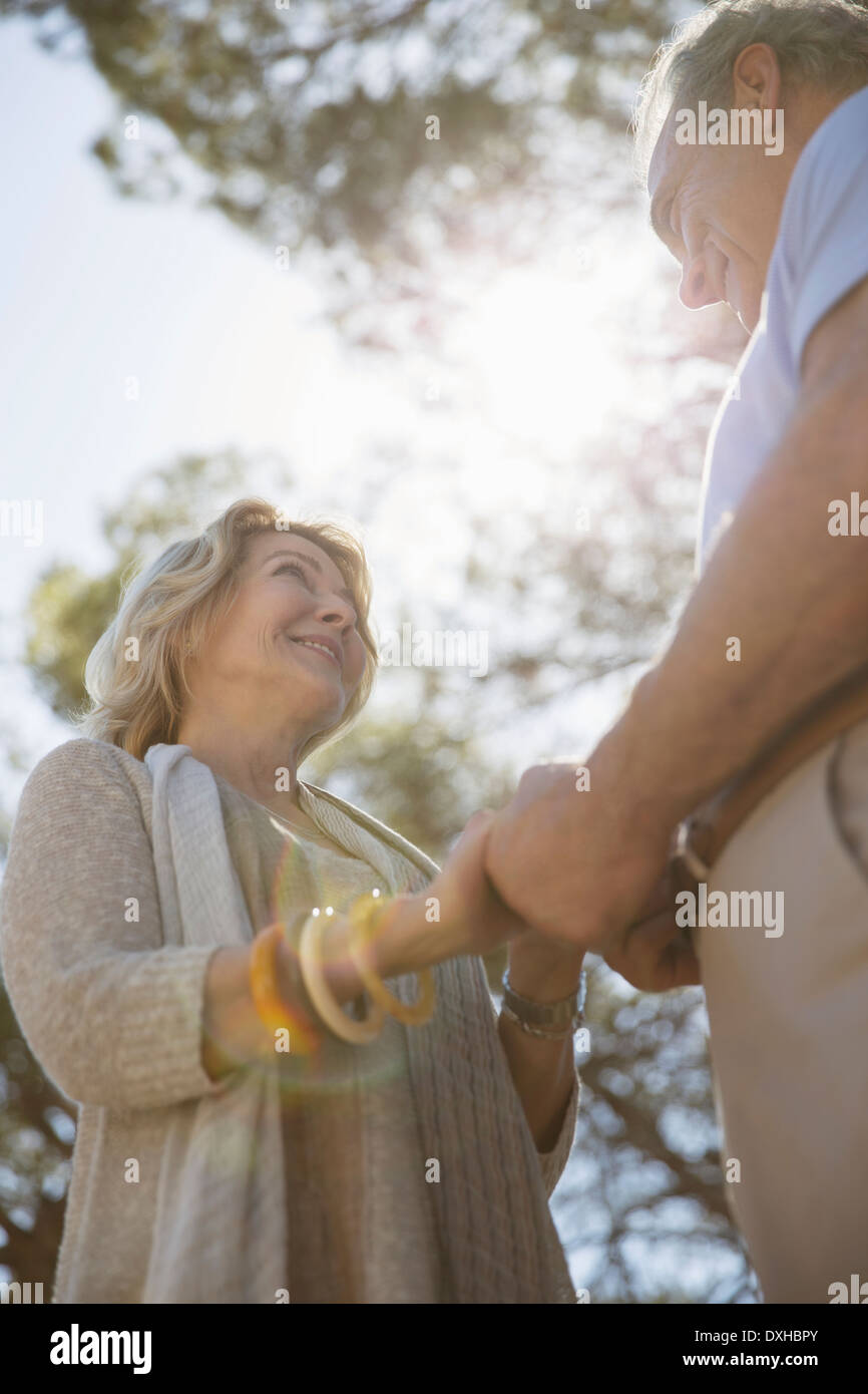 Senior couple holding hands sous les arbres Banque D'Images