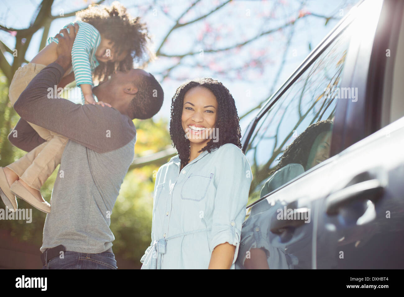 Portrait de femme heureuse avec son mari et sa fille à l'extérieur de voiture Banque D'Images