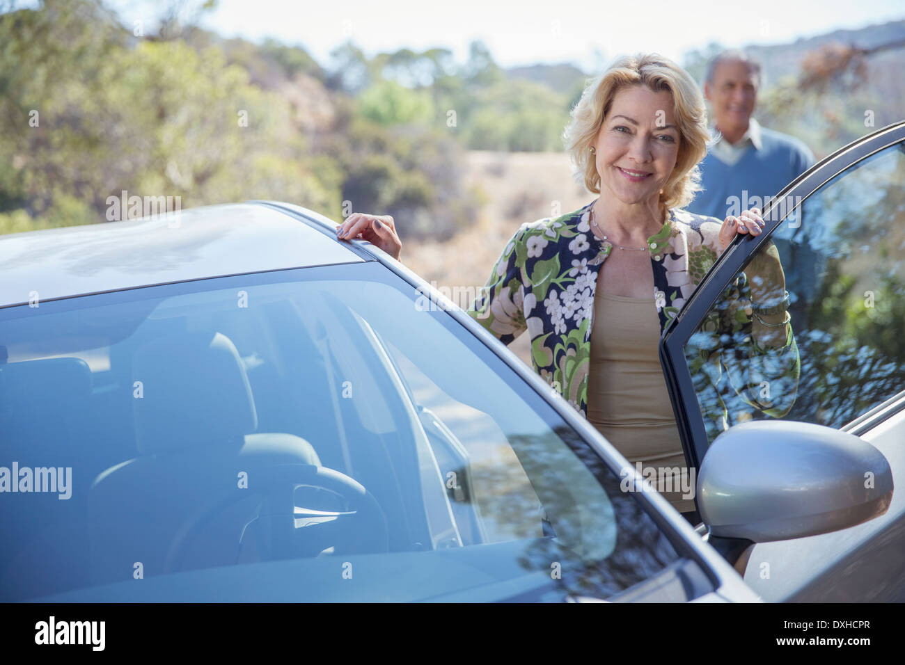 Portrait of senior woman leaning on car Banque D'Images