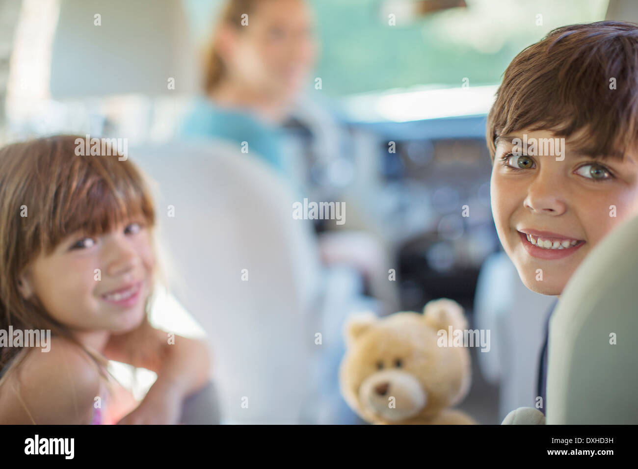 Portrait of happy brother and sister in back seat of car Banque D'Images