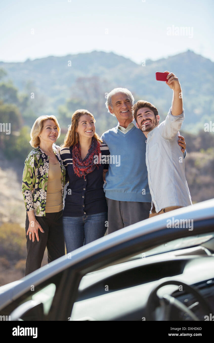 Family taking self-portrait with cell phone parking extérieur Banque D'Images