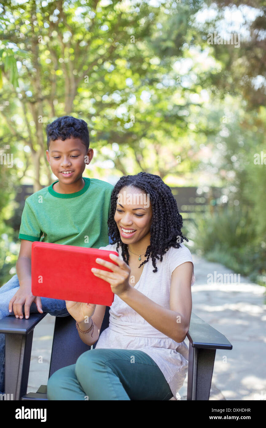 Mère et fils using digital tablet outdoors Banque D'Images