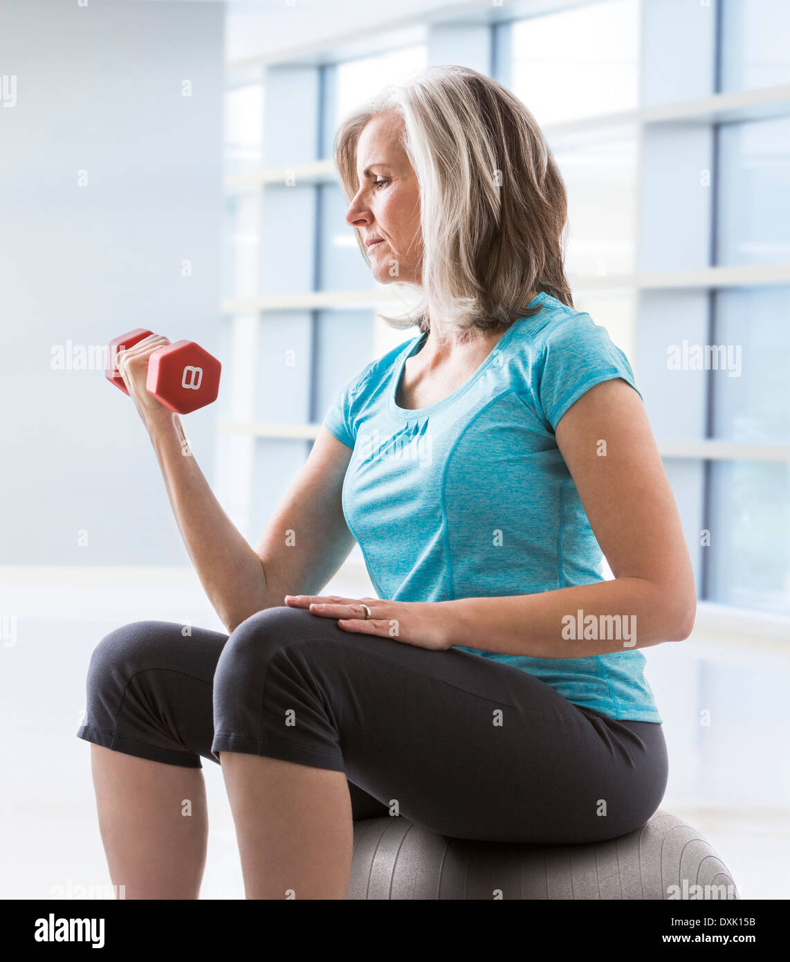 Caucasian woman faisant de biceps avec haltère Banque D'Images