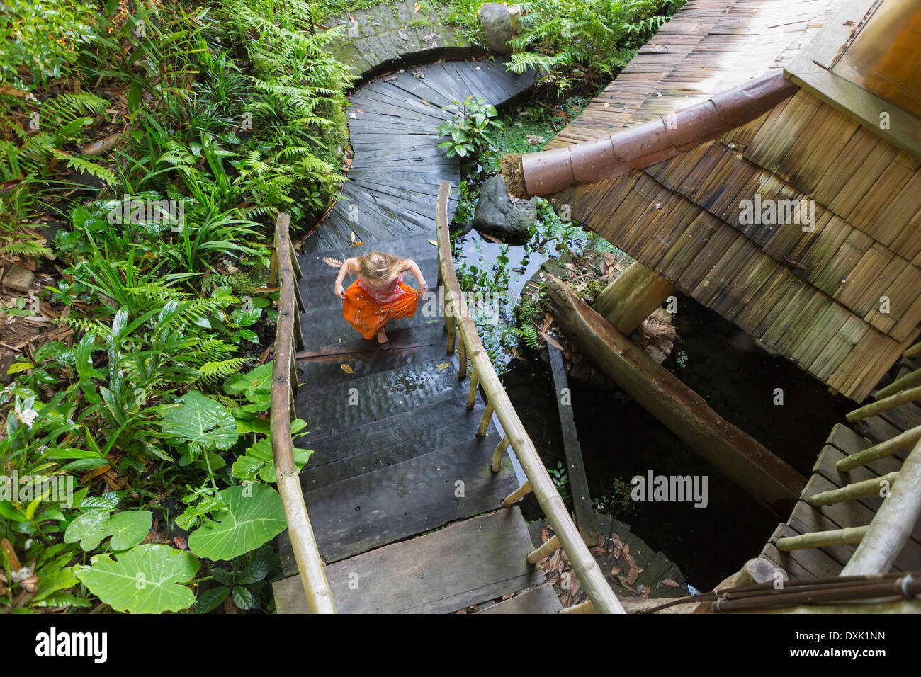 Caucasian girl running up étapes de jardin, Ubud, Bali, Indonésie Banque D'Images