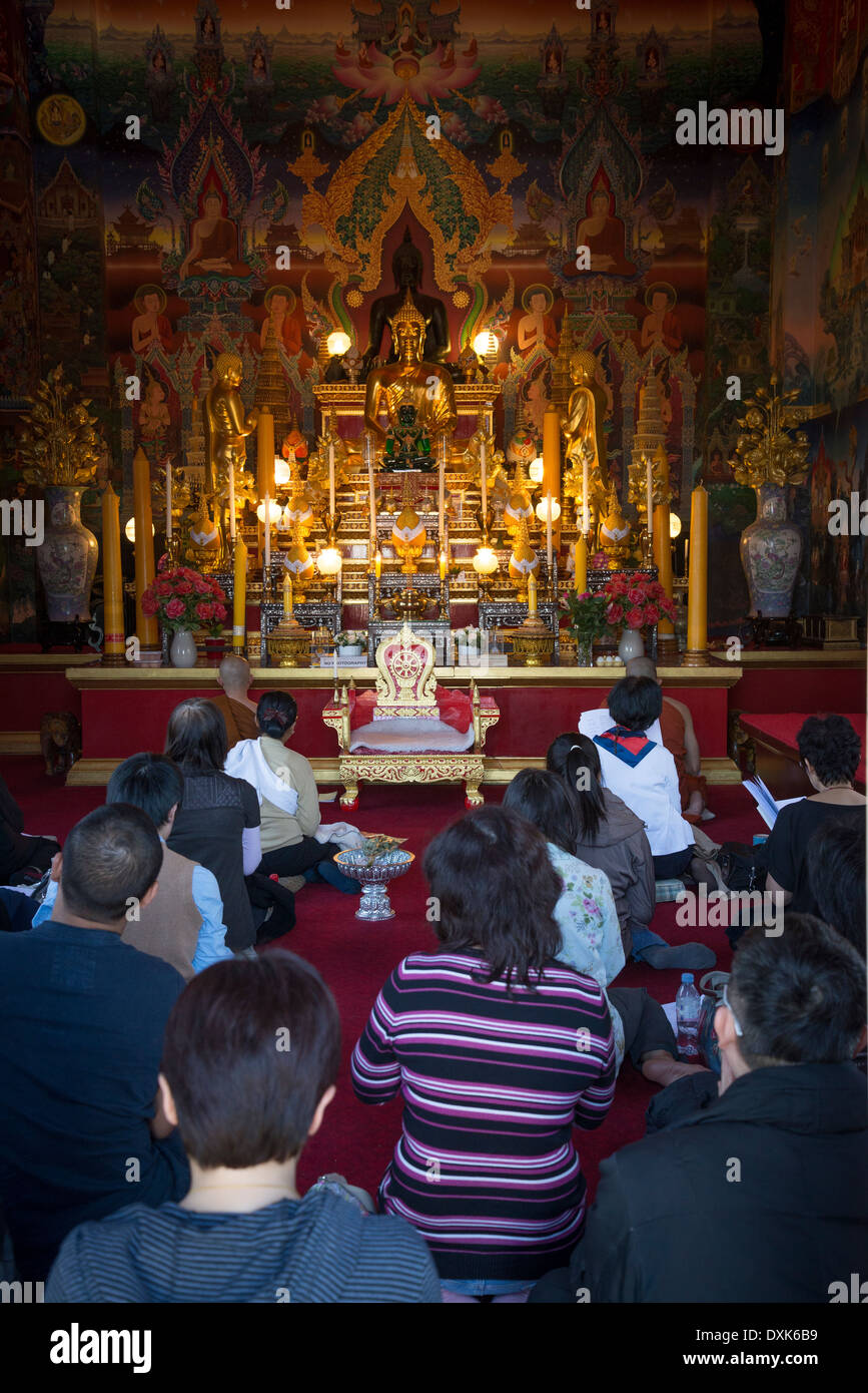 Wat Buddhapadipa, les gens prier à l'intérieur du temple bouddhiste thaï, London, Londres, Royaume-Uni Banque D'Images