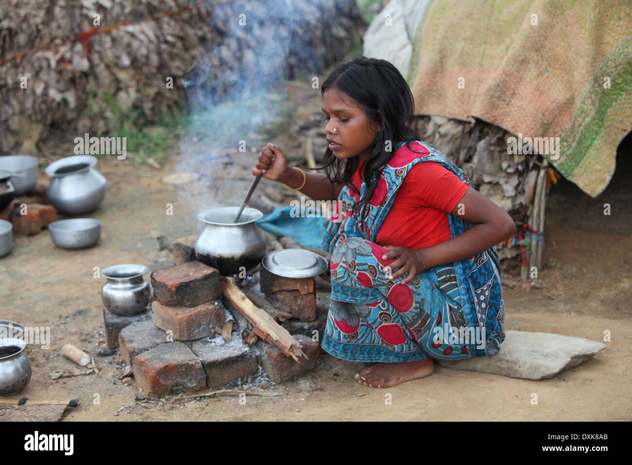 Femme Tribal à la cuisson des aliments sur l'âtre. Bhuija Musahar ou tribu. Keredari et village, district de bloc Hazaribaug, Jharkhand, India. Banque D'Images