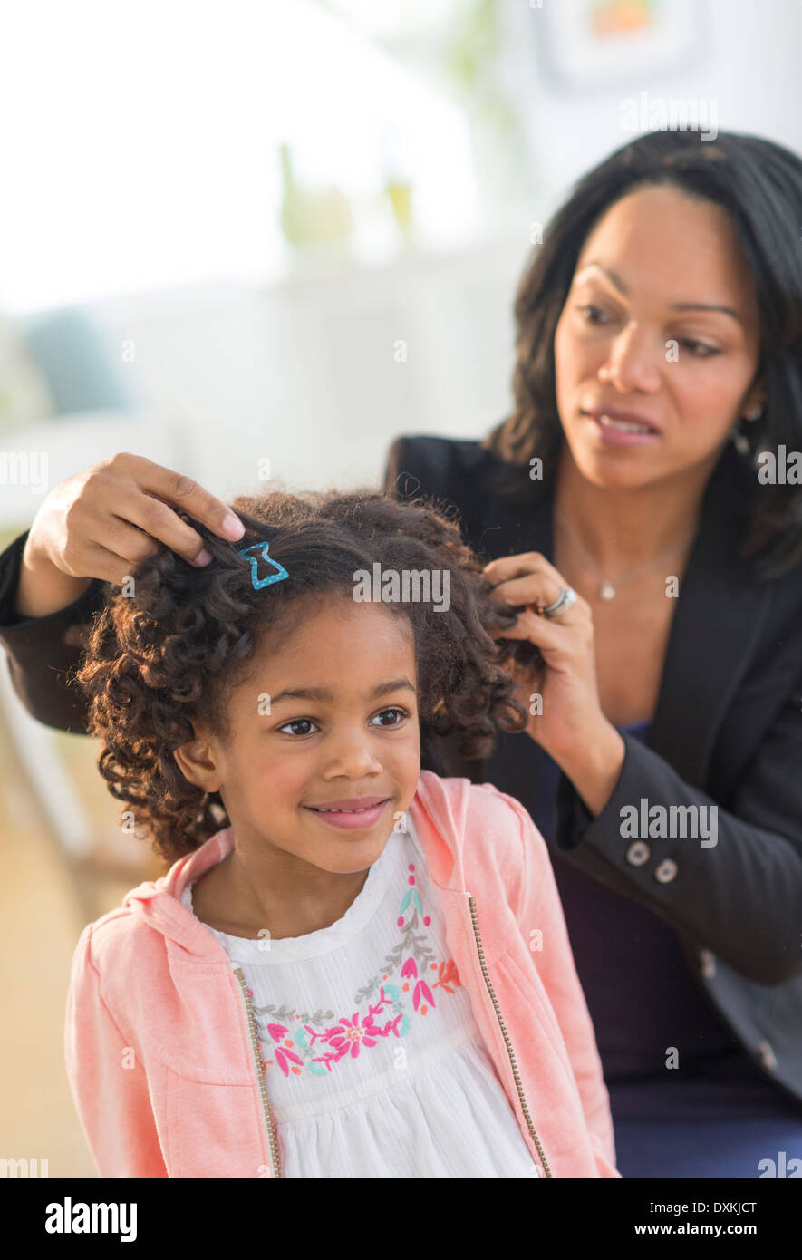 African American mother fixing daughter's hair Banque D'Images