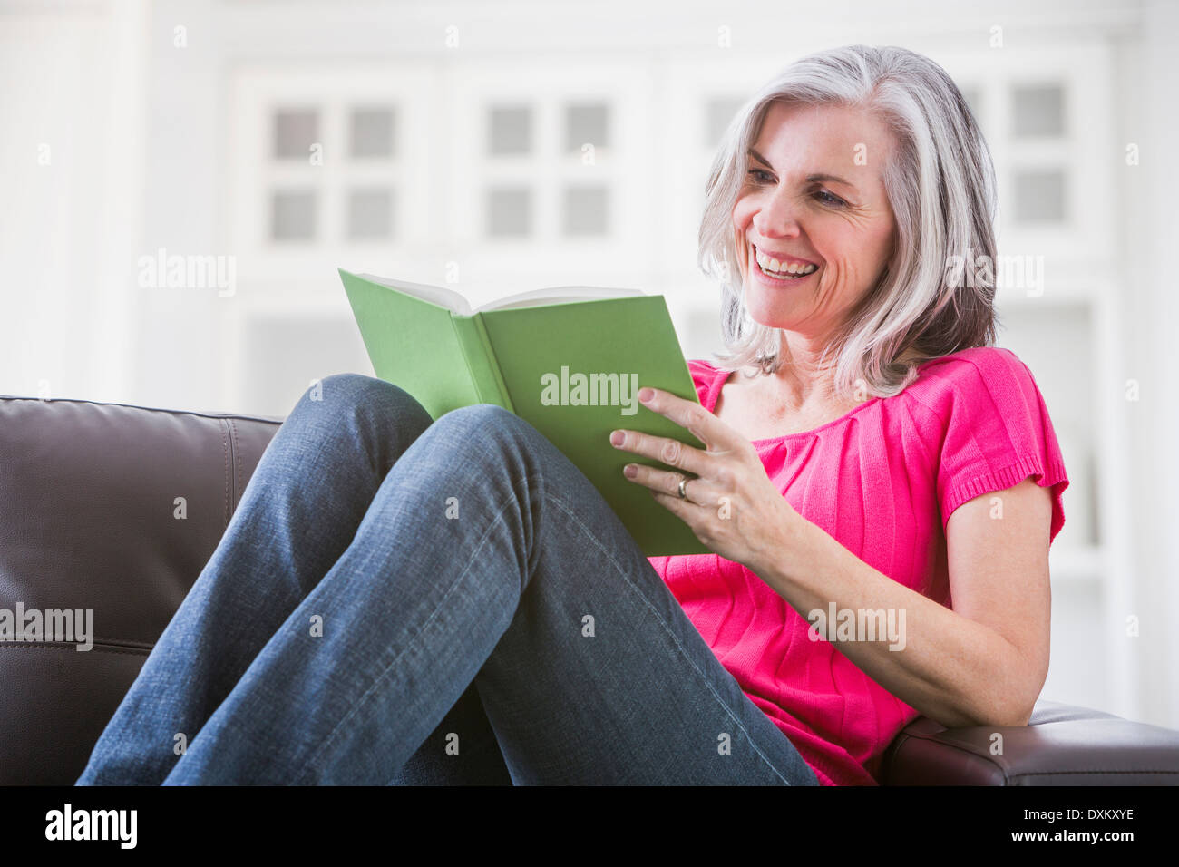 Happy young woman on sofa Banque D'Images
