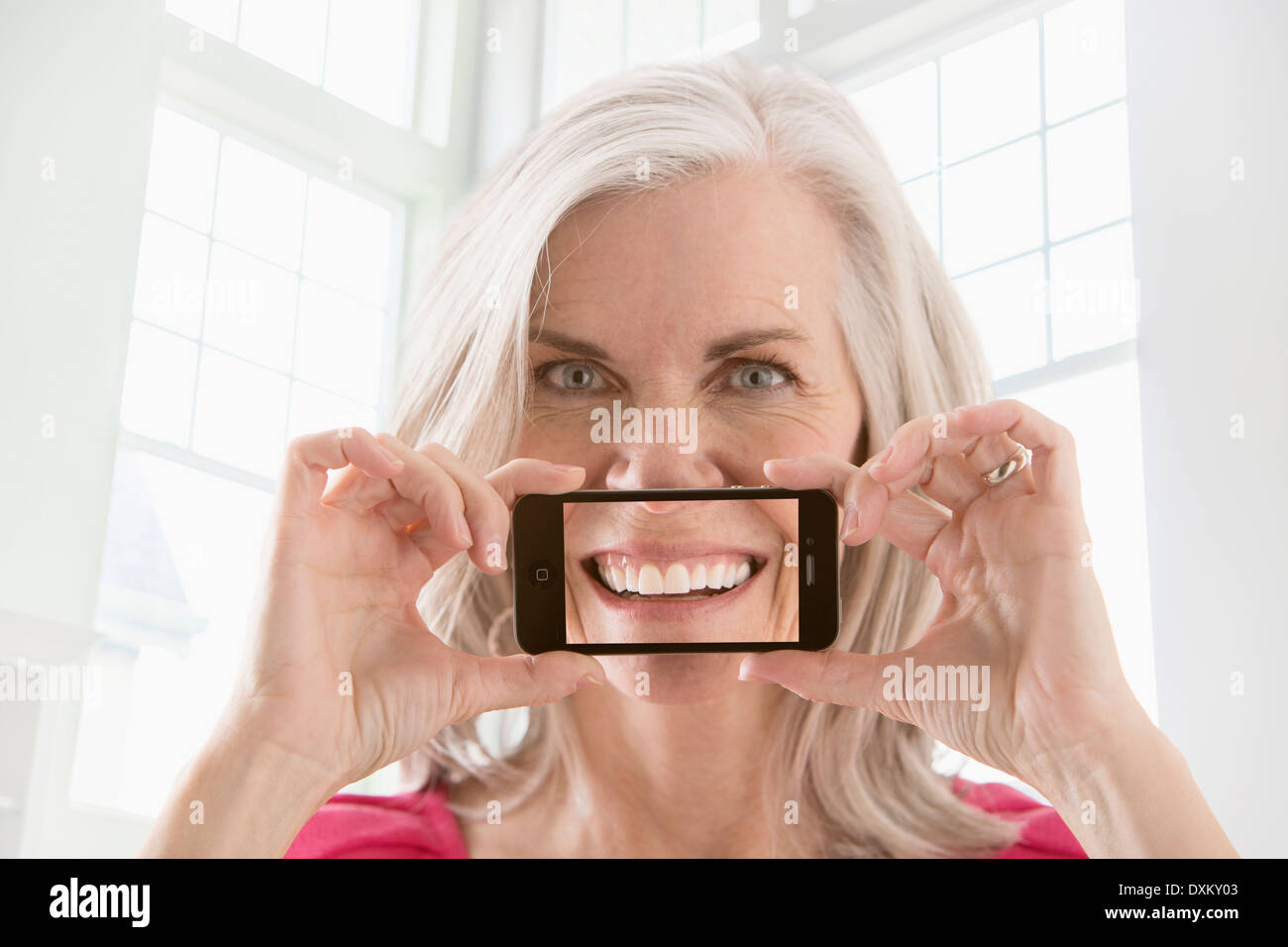 Caucasian woman holding cell phone avec l'image du sourire Banque D'Images