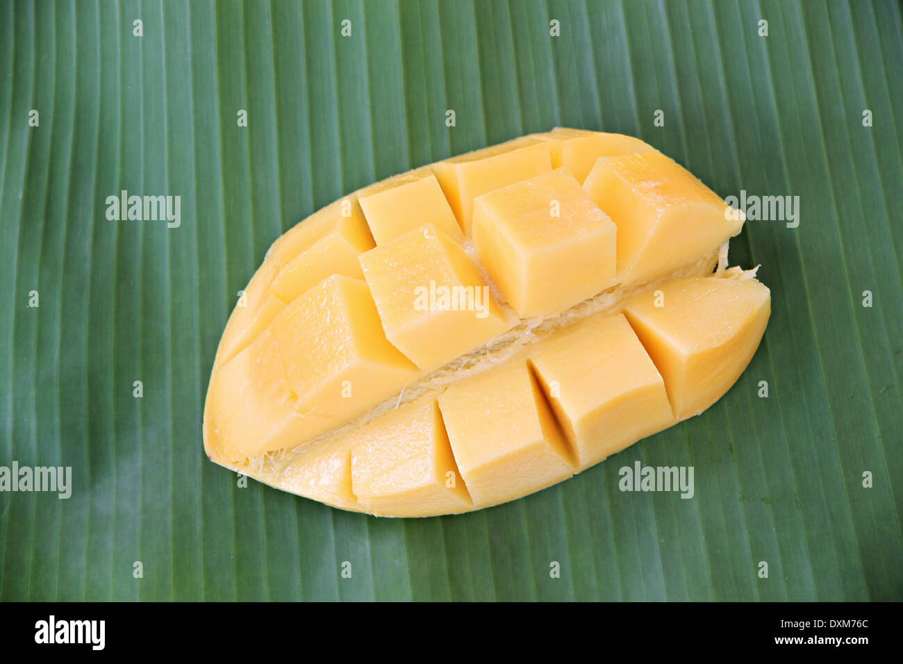 Mangue mûre avec des tranches sur des feuilles de bananiers de l'arrière-plan. Banque D'Images