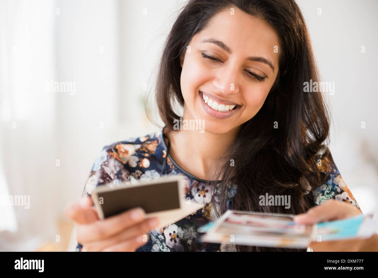 Smiling Asian woman looking at photographs Banque D'Images