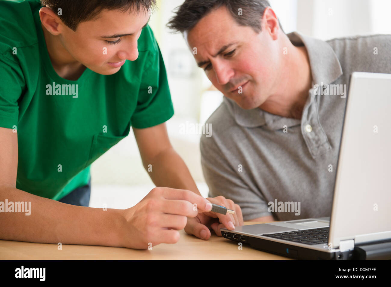 Portrait fils père montrant comment utiliser une clé USB sur ordinateur portable Banque D'Images