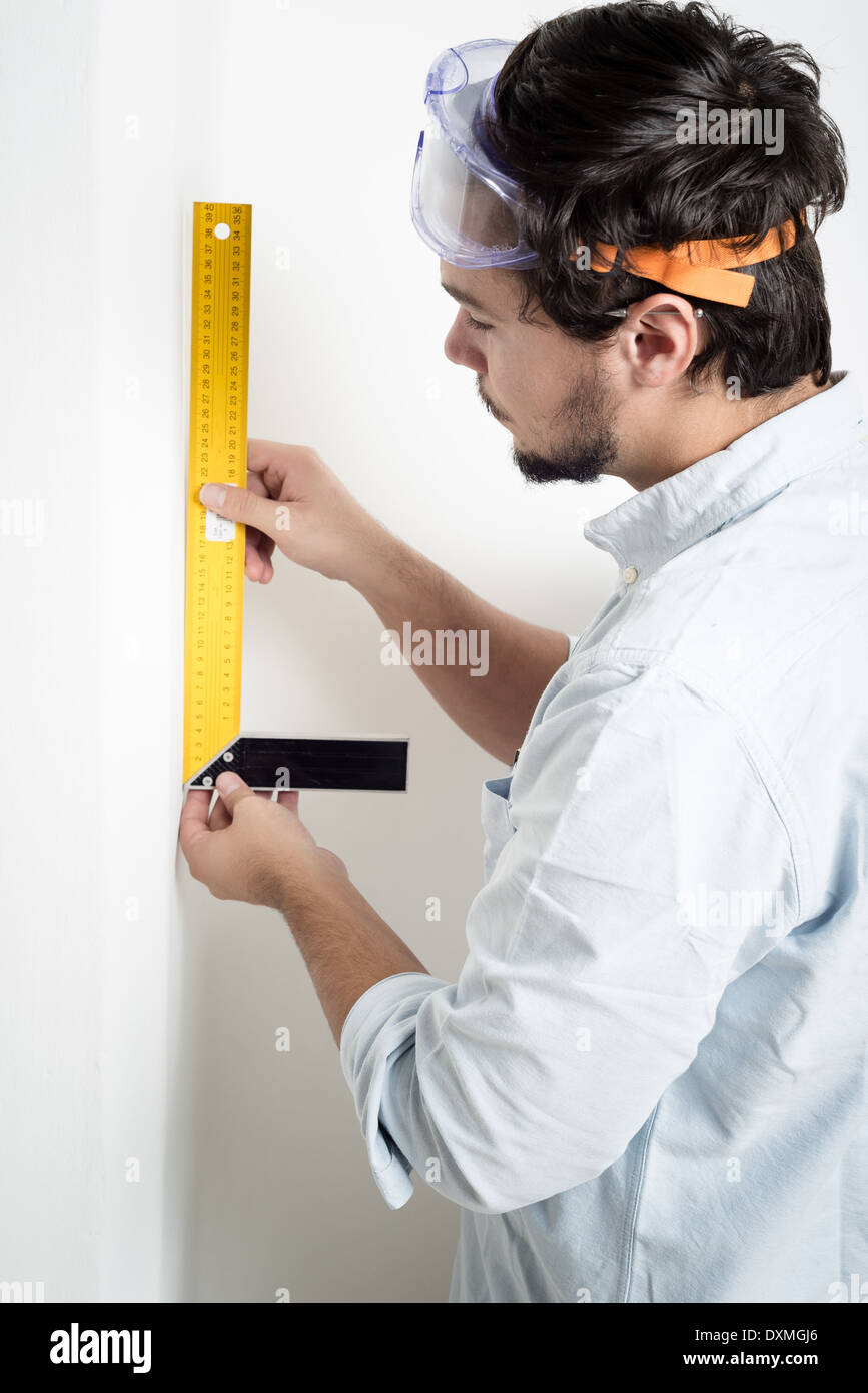 Mesure Fonctionnante De Bricolage De Jeune Homme Avec Le Mètre Image stock  - Image du appartement, domestique: 35491477