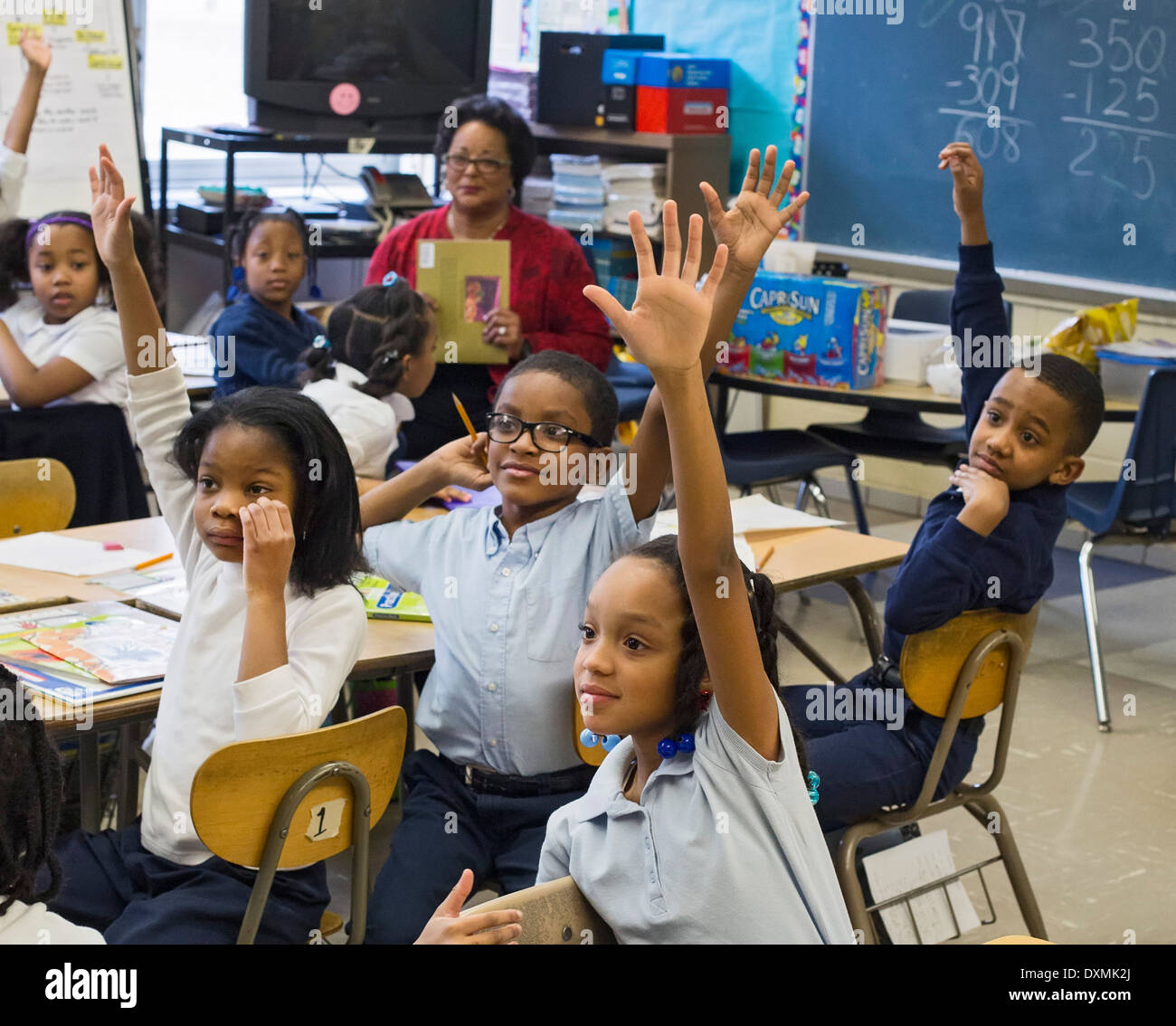 Detroit, Michigan - Les élèves de l'école élémentaire Chrysler poser des questions après avoir entendu un volontaire de lire un livre pour enfants. Banque D'Images