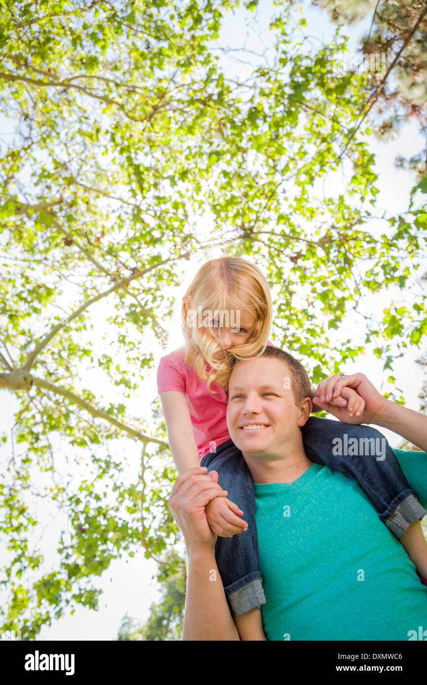 Cute Young Girl Piggyback Rides sur ses épaules de papas à l'extérieur du parc. Banque D'Images