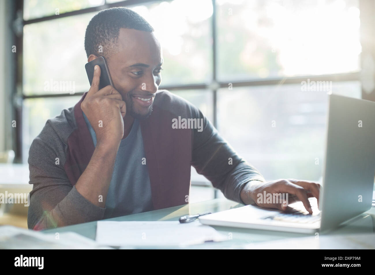 Businessman talking on cell phone and using laptop Banque D'Images