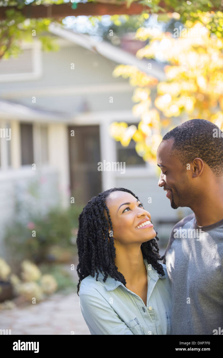 Heureux couple hugging outside house Banque D'Images