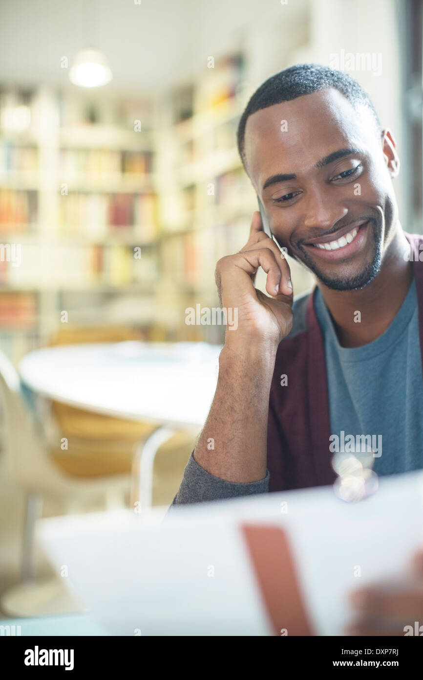 Smiling man with paperwork talking on cell phone Banque D'Images