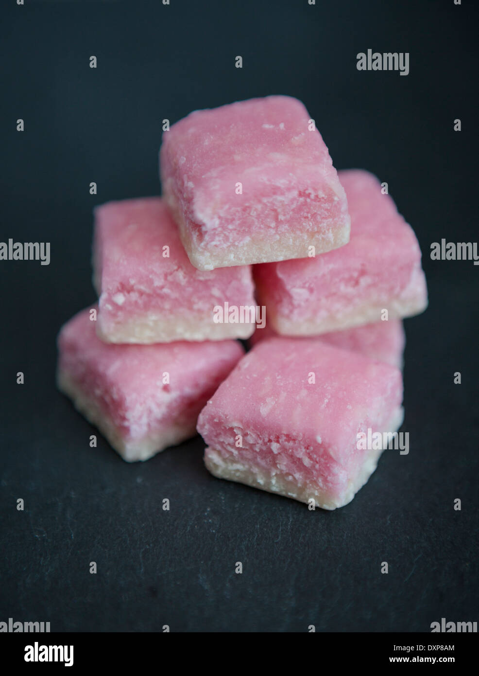 Un tas de glace coco rose et blanc, un doux traditionnel fabriqué à partir de noix de coco desséchée et le sucre, sur une ardoise servant de la plaque. Banque D'Images