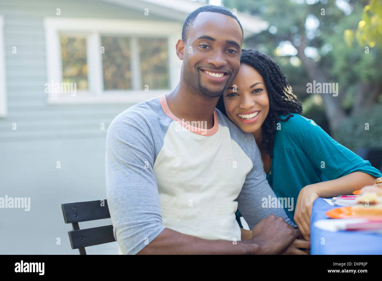 Portrait of happy couple holding hands at table patio Banque D'Images