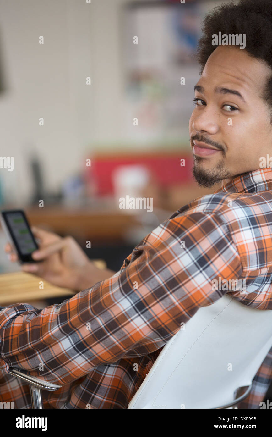 Portrait of man text messaging with cell phone Banque D'Images