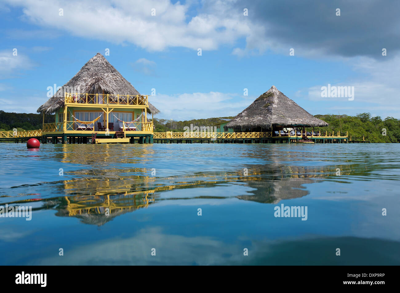 À partir de la surface de l'eau, bungalow tropical et restaurant sur pilotis sur la mer avec toit de chaume, l'île de Colon, Caraïbes, Panama Banque D'Images