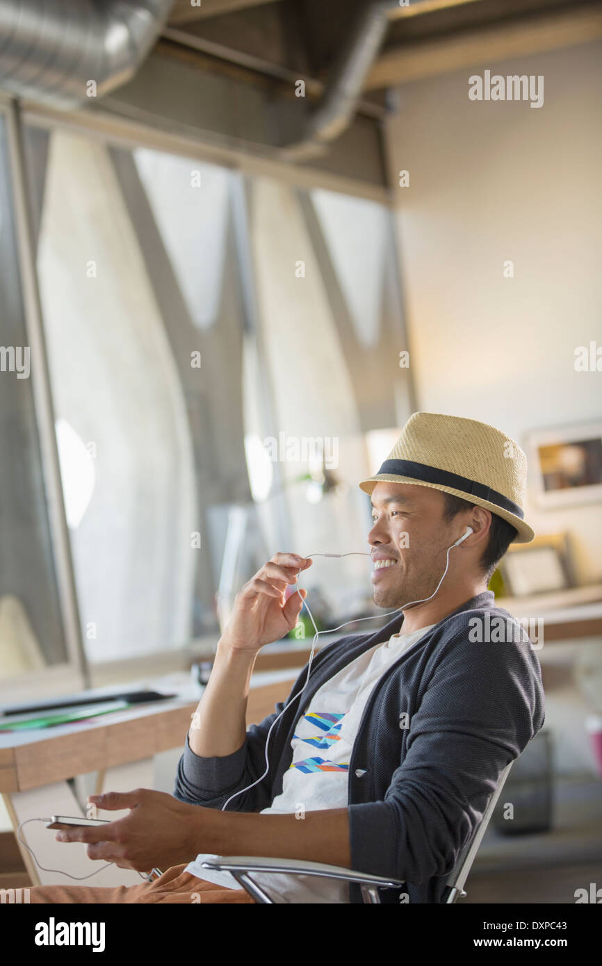 Businessman à l'aide de dispositif mains libres avec cell phone in office Banque D'Images