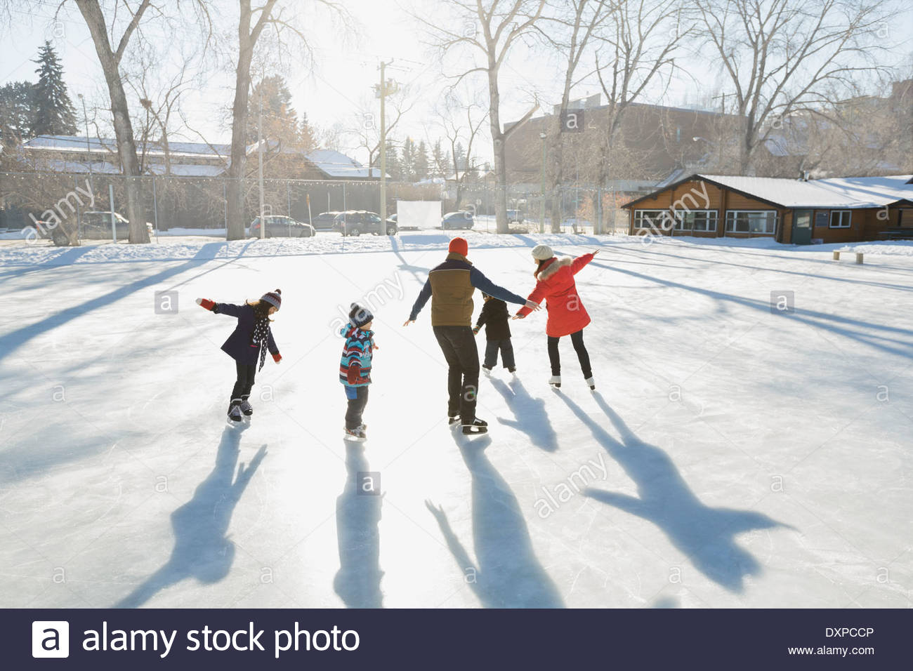 Famille patinage sur une patinoire extérieure ensemble Banque D'Images