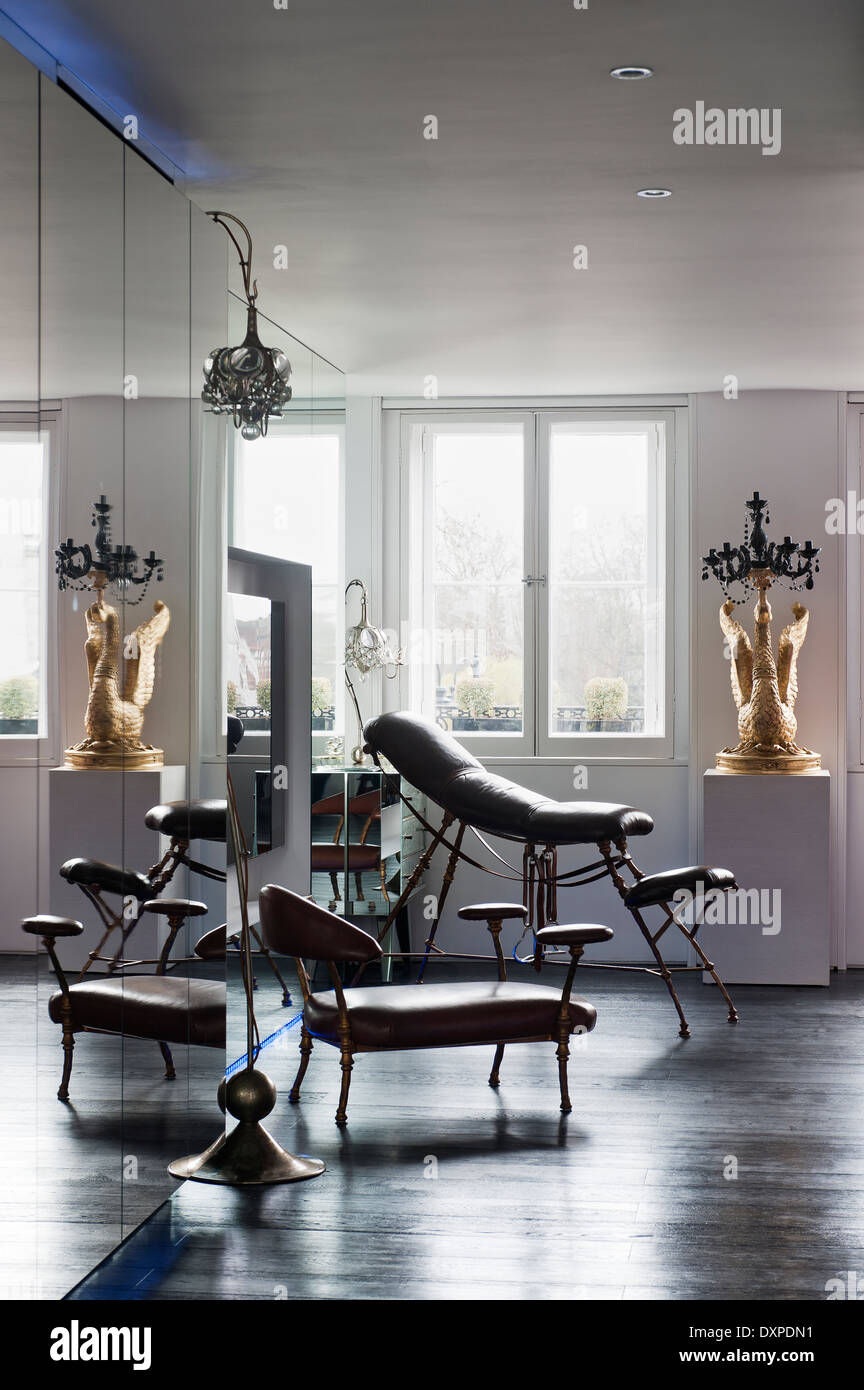 Chaises de Tally Ho par Mark Brazier-Jones dans chambre avec placards en miroir et parquet foncé Banque D'Images