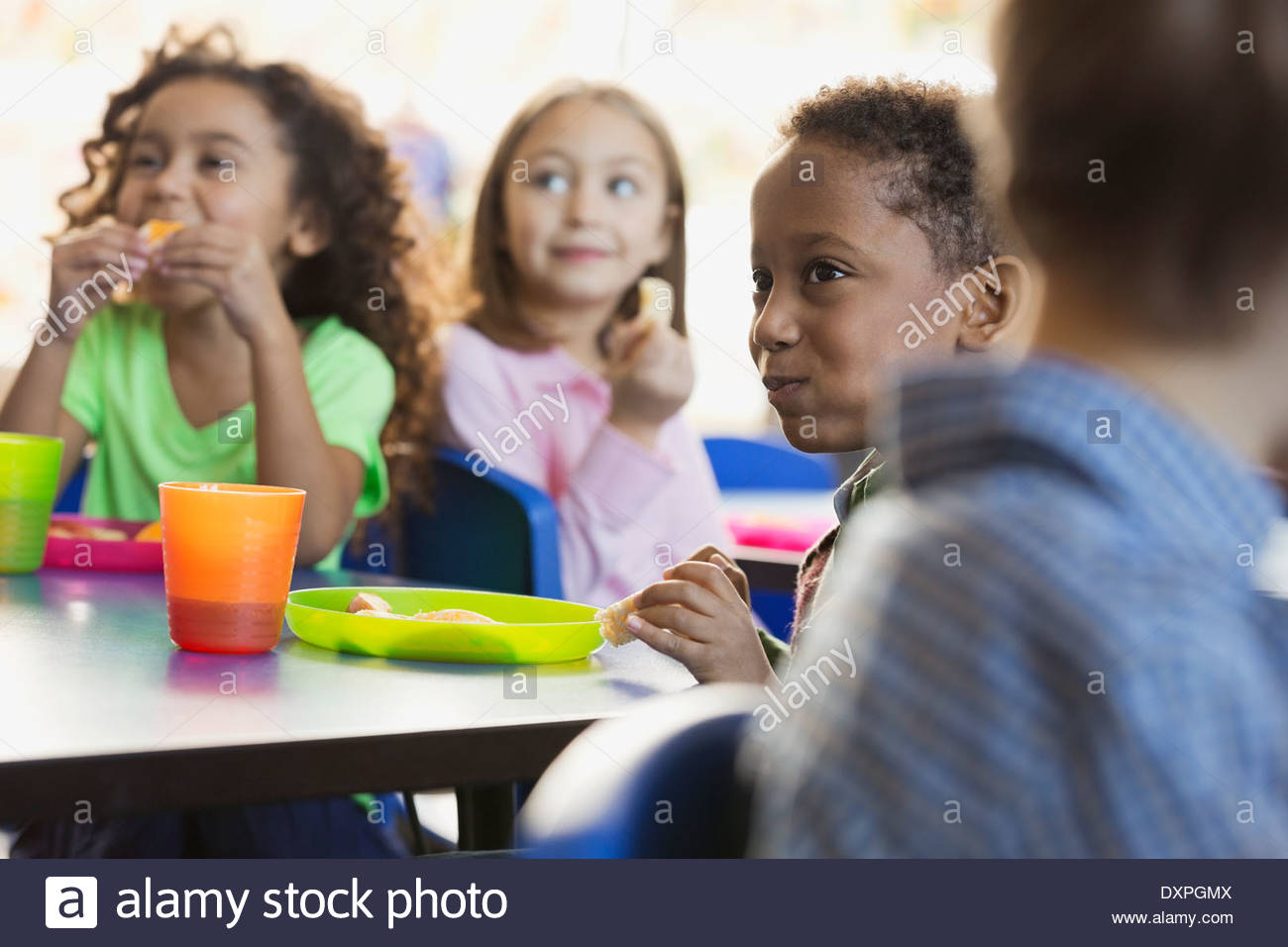 Les enfants de manger des collations dans la salle de classe de l'école élémentaire Banque D'Images