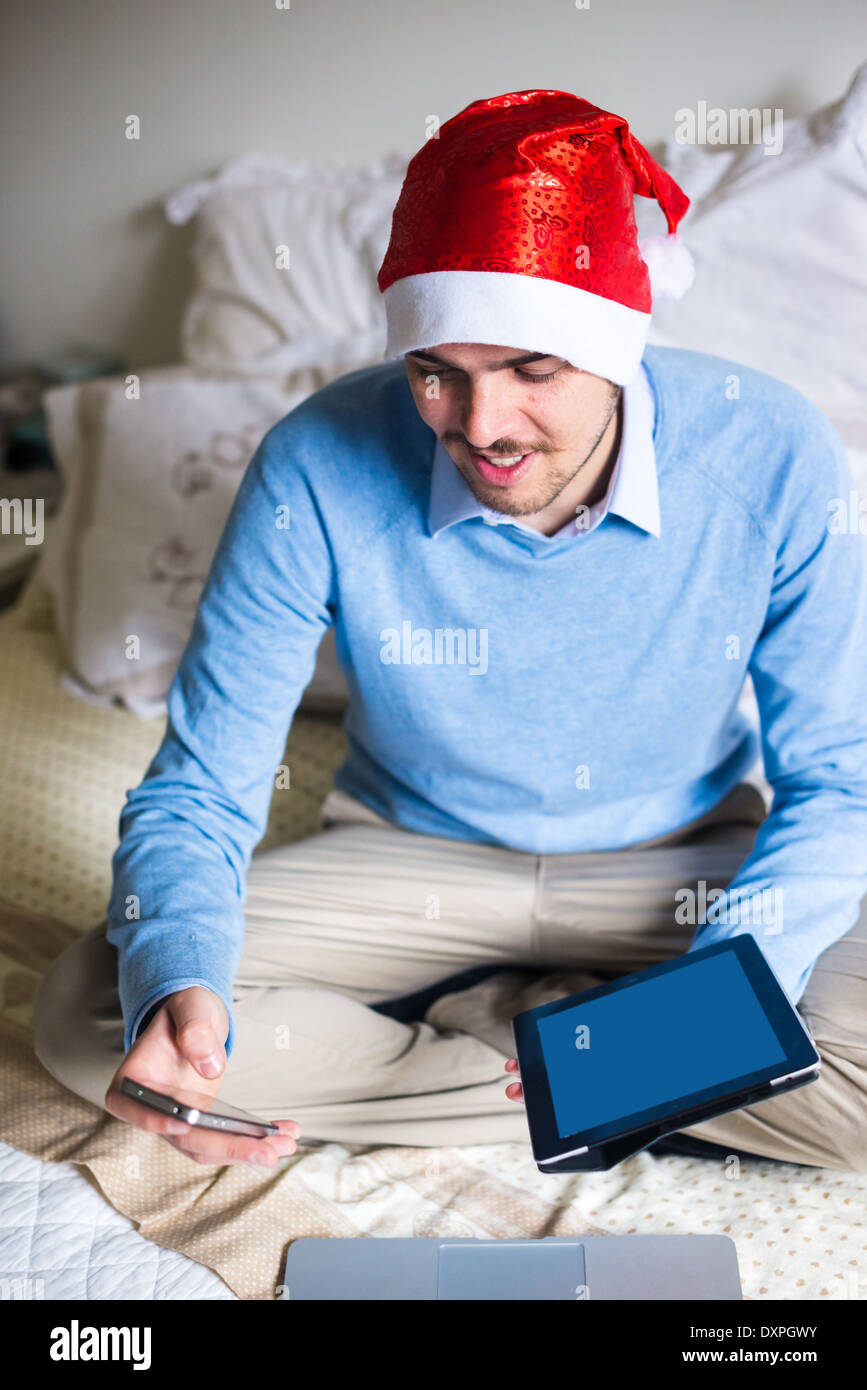 L'homme d'affaires élégant noël multitâche avec l'aide d'appareils à la maison Banque D'Images