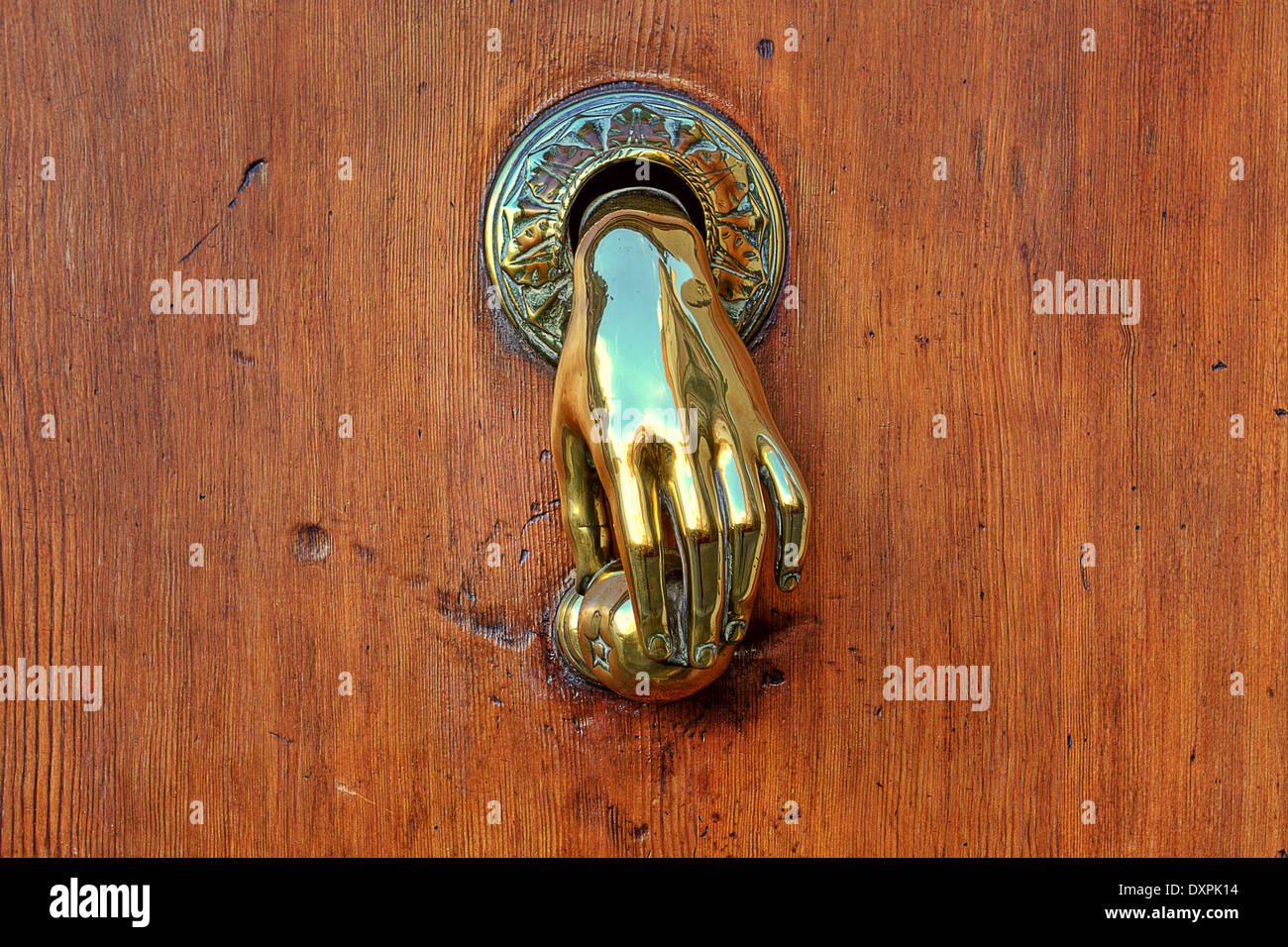 Bouton de porte d'or en forme de main sur la porte en bois brun sur Valence, Espagne. Banque D'Images
