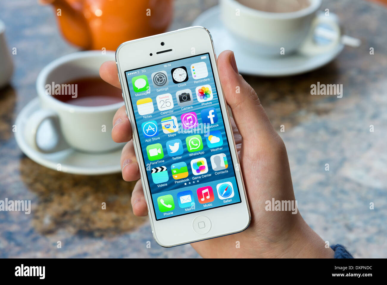 Écran d'accueil de iOS 7 Apple iPhone 5 blanc dans un café Banque D'Images